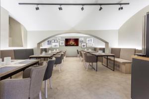 a dining room with tables and chairs and pictures on the wall at Avenue Legerova 19 in Prague