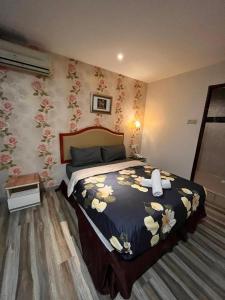 a bedroom with a bed with a flower patterned wall at MR Hotel Nusa Bestari in Skudai