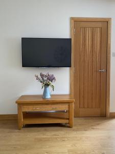 StuartfieldにあるThe Denのテレビの前のテーブルの花瓶