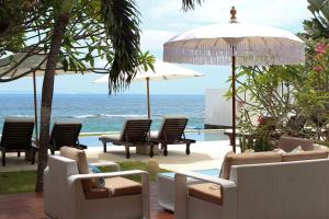 a view of the ocean from a resort with chairs and umbrellas at Villa Oceana, Candidasa in Candidasa