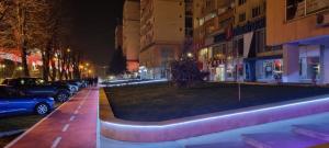 une rue de la ville la nuit avec des voitures garées dans la rue dans l'établissement Best Apartment Central, à Hunedoara