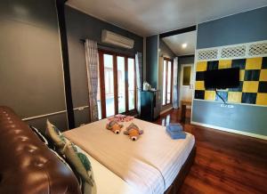 a bedroom with two teddy bears on a bed at Aen Guy Boutique Hotel in Sukhothai