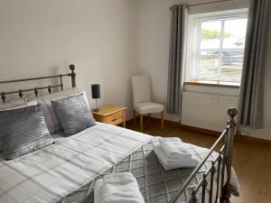 a bedroom with a large bed and a window at The Den in Stuartfield