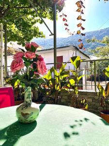 um vaso com flores cor-de-rosa sentado numa mesa em Villa Simotas 4 Four em Poros