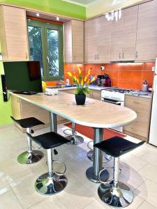 uma cozinha com uma grande mesa de madeira e cadeiras em Villa Simotas 4 Four em Póros