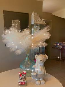 a teddy bear sitting next to a vase with feathers at Hotel Canal Aigues Mortes in Aigues-Mortes