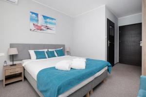 sypialnia z dużym łóżkiem z niebiesko-białymi poduszkami w obiekcie Azul w Grzybowie