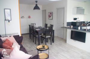 ein Wohnzimmer und eine Küche mit einem Tisch und Stühlen in der Unterkunft Cottage normand chaleureux avec piscine 
