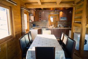eine Küche mit einem Tisch und Stühlen in einer Hütte in der Unterkunft Villa Route Rugove in Peja