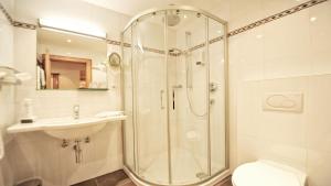 y baño con ducha, lavabo y aseo. en Hotel Königsblick by keyone, en Fulpmes
