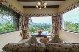 a living room with two couches and a large window at Swiss Valley Hip Resort in Suan Phung
