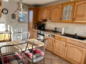 a kitchen with wooden cabinets and a table and chairs at "Elbparadies" Ferienhaus am Niegripper See mit Pool in Burg bei Magdeburg