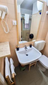 a bathroom with a sink and a toilet and a mirror at Ecorooms Ferrara in Ferrara