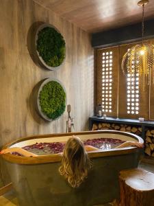 a woman sitting in a large tub in a room at Boutique Hotel Apsuana Rose in Gagra