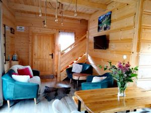 a log cabin living room with a table and chairs at Zymbiańsko Chałupa z balią na wyłączność in Ząb