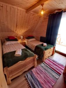 a bedroom with two beds in a log cabin at Zymbiańsko Chałupa z balią na wyłączność in Ząb