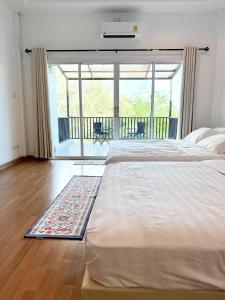 a bedroom with a large bed and a balcony at Sky&Sea Cha-AM Beach in Cha Am
