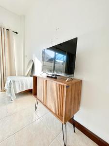 a flat screen tv sitting on top of a wooden entertainment center at Sky&Sea Cha-AM Beach in Cha Am