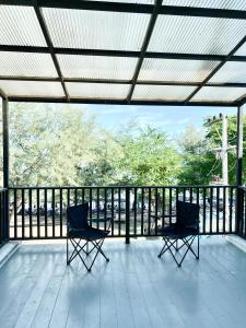 twee stoelen op een veranda met een leuning bij Sky&Sea Cha-AM Beach in Cha Am