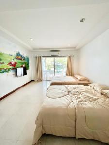 a bedroom with two beds and a painting on the wall at Sky&Sea Cha-AM Beach in Cha Am