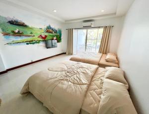 a bedroom with two beds and a painting on the wall at Sky&Sea Cha-AM Beach in Cha Am