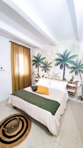 a bedroom with a large bed with palm trees on the wall at Ecorooms Ferrara in Ferrara