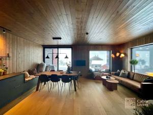 a living room with a couch and a table and chairs at Brand new Chalet-apart slope Hafjell Mosetertoppen in Øyer