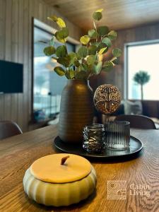 uma mesa de madeira com uma vela e um vaso em Brand new Chalet-apart slope Hafjell Mosetertoppen em Øyer