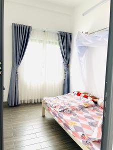 a bedroom with a bed with blue curtains at Thông Villa in B'su M'rac