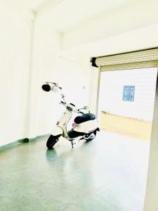 un scooter garé dans une chambre avec porte dans l'établissement Thông Villa, à B'su M'rac