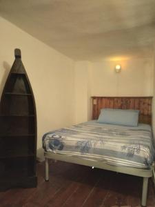 una camera da letto con un letto con testiera in legno di La tana del porto a Napoli