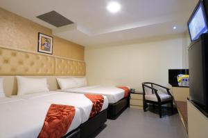 A bed or beds in a room at Sandpiper Hotel Singapore