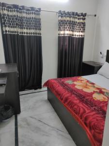 a bedroom with a bed with red sheets and curtains at hotel khubsaras palace by chhabra's in Agra