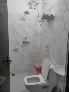 biała łazienka z toaletą i umywalką w obiekcie hotel khubsaras palace by chhabra's w mieście Agra