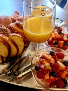 - un plateau avec une assiette de fruits et un verre de jus dans l'établissement Les Rêves by Isa, à Arras