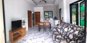 a living room with a couch and a television at Villa MILTONIA in Ban Ai Dao