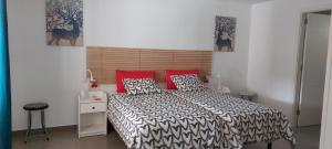 a bedroom with a large bed with red pillows at Villa Tauro Beach & Golf in La Playa de Tauro +24 photos
