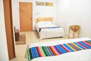 een hotelkamer met twee bedden in een kamer bij Hostal Casa Bohemia in Mérida +18 foto's