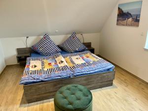 ein Schlafzimmer mit einem Bett mit Kissen und einem Stuhl in der Unterkunft Backbord Greetsiel in Krummhörn