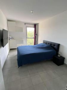 - une chambre avec un lit bleu et une fenêtre dans l'établissement Jolie T2 dans village provençale, au Luc