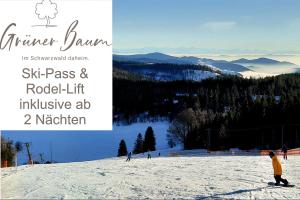 Un uomo che cavalca uno snowboard lungo un pendio ricoperto di neve di Grüner Baum Naturparkhotel & Schwarzwald-Restaurant a Todtnau
