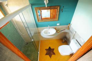 a bathroom with a sink and a toilet and a mirror at Casinha Caiçara in Ilhabela