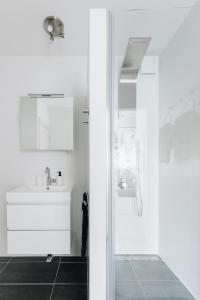 een witte badkamer met een wastafel en een douche bij Luxurious Private Studio Amsterdam Zuid in Amsterdam