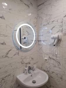 La salle de bains blanche est pourvue d'un lavabo et d'un miroir. dans l'établissement Апартамент 3 А, à Varna