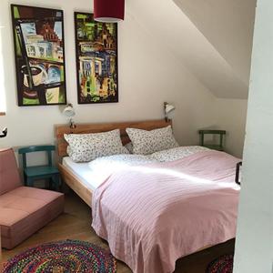 - une chambre avec un lit, une chaise et des photos sur le mur dans l'établissement Ferienwohnungen Grundmühle, à Nordheim vor der Rhön