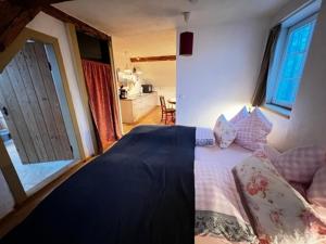 a bedroom with a large bed and a kitchen at Ferienwohnungen Grundmühle in Nordheim vor der Rhön