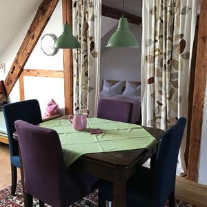 einen Esstisch mit Stühlen und ein Zimmer mit einem Bett in der Unterkunft Ferienwohnungen Grundmühle in Nordheim vor der Rhön