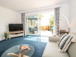 a living room with a couch and a tv at Little Honeynook in Kingsbridge