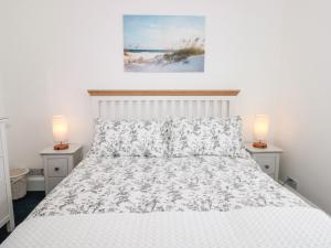 1 dormitorio con 1 cama blanca y 2 lámparas en las mesas en Little Honeynook en Kingsbridge