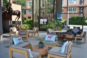 a patio with chairs and a table and a horse statue at Blissful beach Cha-am in Cha Am